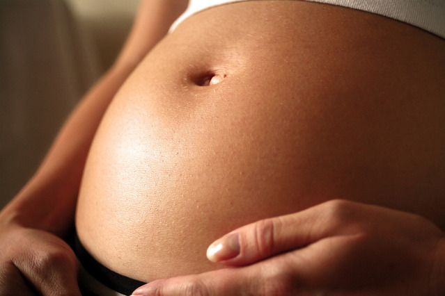 Tehotná žena si drží holé brucho.jpg
